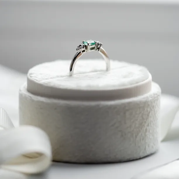Gold ring with emerald and salt and pepper diamonds shown from the side