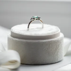 Gold ring with emerald and salt and pepper diamonds shown from the side