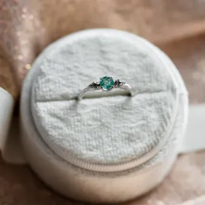 Close-up of the KIM gold ring with emerald and kite salt and pepper diamonds