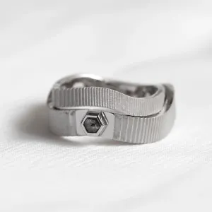 Close-up of JACKLYN wedding rings with textured bands and salt and pepper diamond