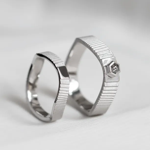 JACKLYN wedding rings displayed upright, with textured bands and salt and pepper diamond
