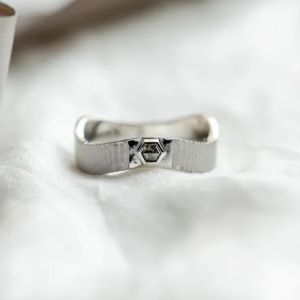 Close-up of a JACKLYN wedding ring with salt and pepper diamond and textured band