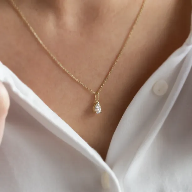 Gold necklace with pear moissanite NAOMI worn on the neck, close-up
