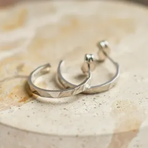 Pair of gold circle earrings in an angled view, showing the hammered surfaces