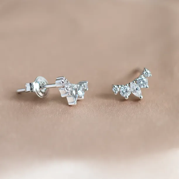 Angled view of JESS gold crawler earrings with moissanites and button closures