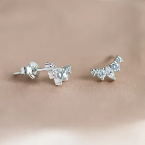 Angled view of JESS gold crawler earrings with moissanites and button closures