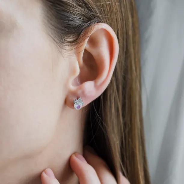 Close-up of a MONY gold earring with moonstone and diamonds worn on the ear