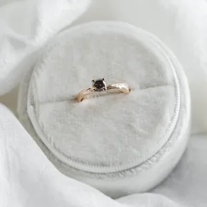 Angled view of the twig-shaped gold ring with a salt and pepper diamond