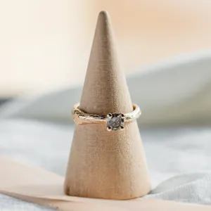 Twig-shaped gold ring with a salt and pepper diamond in a clear product view