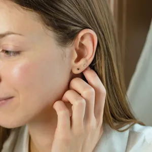 DUNCAN gold stud earring with a black diamond worn on the ear