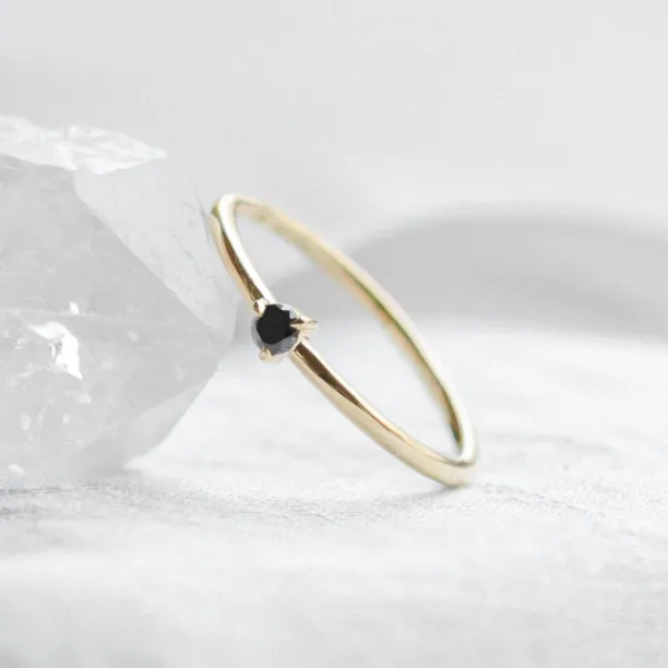 DUNCAN gold ring with a black diamond in an angled view