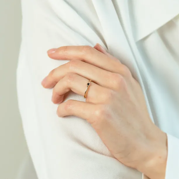 Gold ring with a natural black diamond worn on the hand