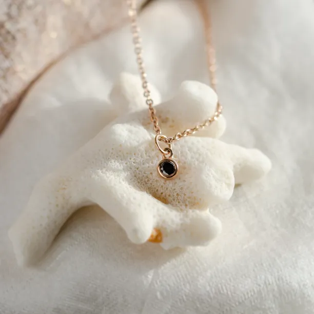 Close-up of the rose gold bezel necklace with black diamond