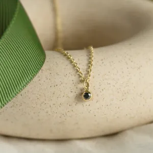 Angled view of the yellow gold bezel necklace with black diamond