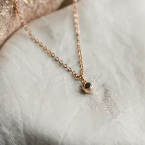 Close-up of the gold bezel pendant with a black diamond