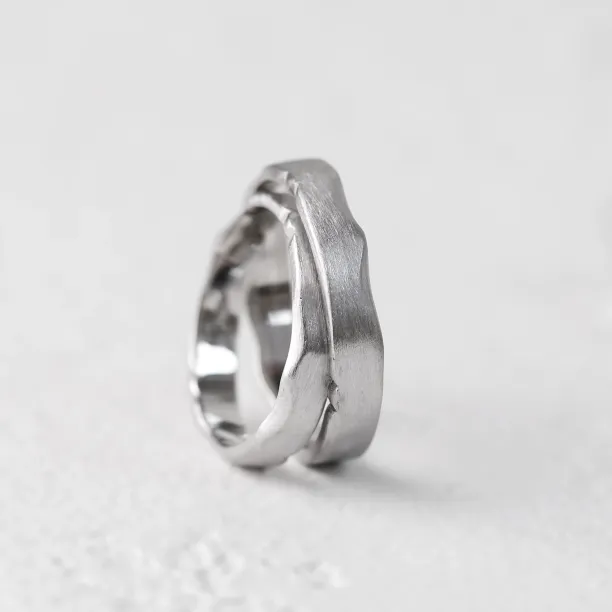Close-up of DANTE gold wedding bands showing their irregular edges