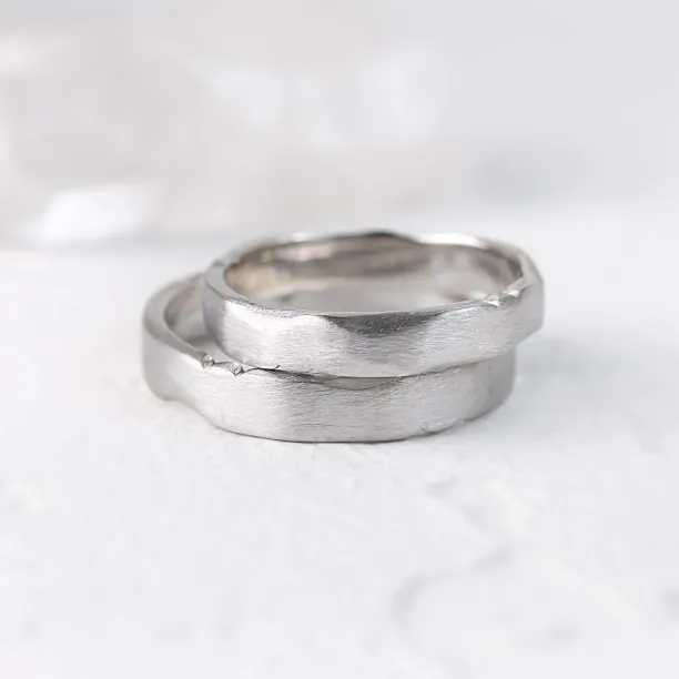 Angled close-up of overlapping DANTE gold wedding bands