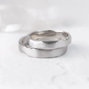 Angled close-up of overlapping DANTE gold wedding bands