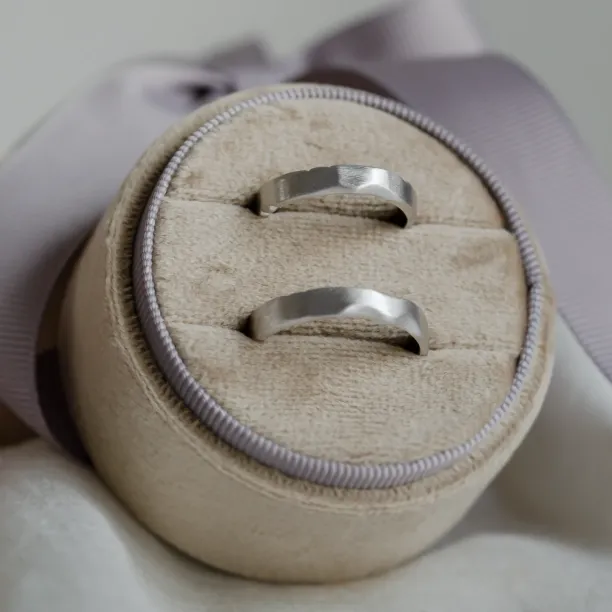 Pair of DANTE gold wedding bands displayed in a ring box