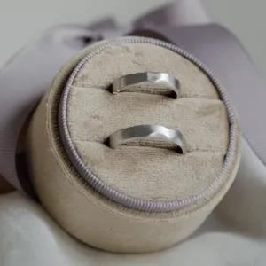Pair of DANTE gold wedding bands displayed in a ring box