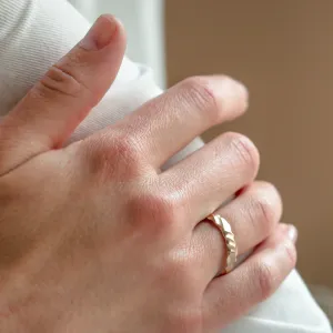 Close-up of the original engraved gold wedding ring ROCK worn on a hand