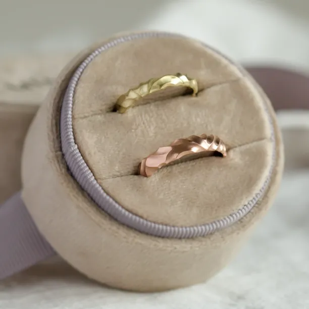 Angled view of a pair of original engraved gold wedding rings ROCK