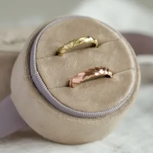 Angled view of a pair of original engraved gold wedding rings ROCK