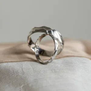 Angled view of a pair of original engraved wedding rings ROCK