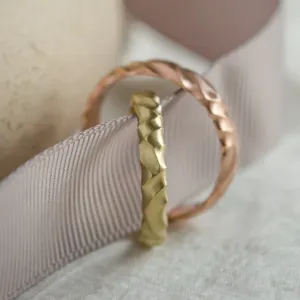 Close-up of a yellow gold 14K ROCK wedding ring with irregular grooves