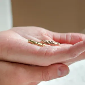 Pair of original ROCK wedding rings resting on an open hand