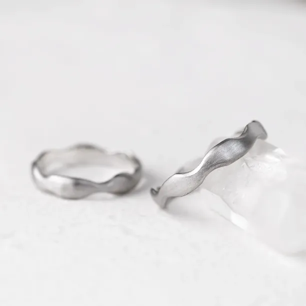 Close-up of a GOCCIO wedding ring with an irregular curved shape