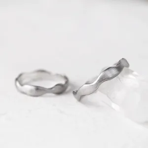 Close-up of a GOCCIO wedding ring with an irregular curved shape