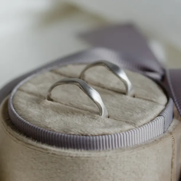 Close-up of the curved profiles of the GOCCIO wedding rings