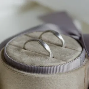 Close-up of the curved profiles of the GOCCIO wedding rings