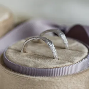 Close-up of MUSK gold wedding bands showing their irregular textured surfaces