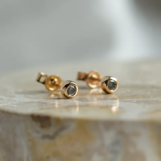 Angled view of ANISE salt and pepper diamond earrings as a pair