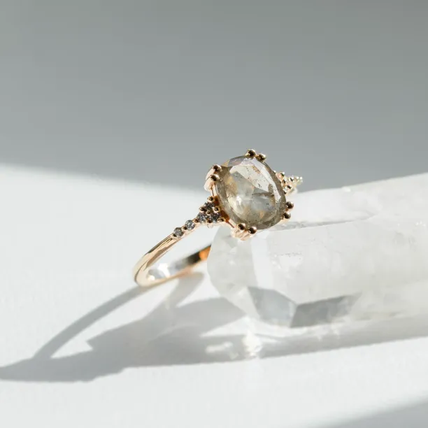 Angled view of the AGNES gold ring with a salt and pepper diamond