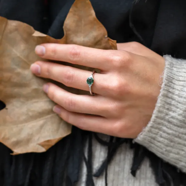 Moss agate and diamond engagement ring worn on a hand
