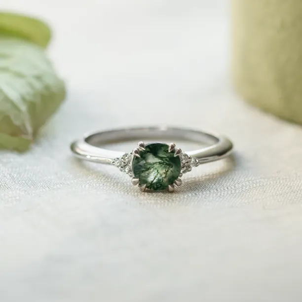 Moss agate engagement ring with diamonds in a clear front view