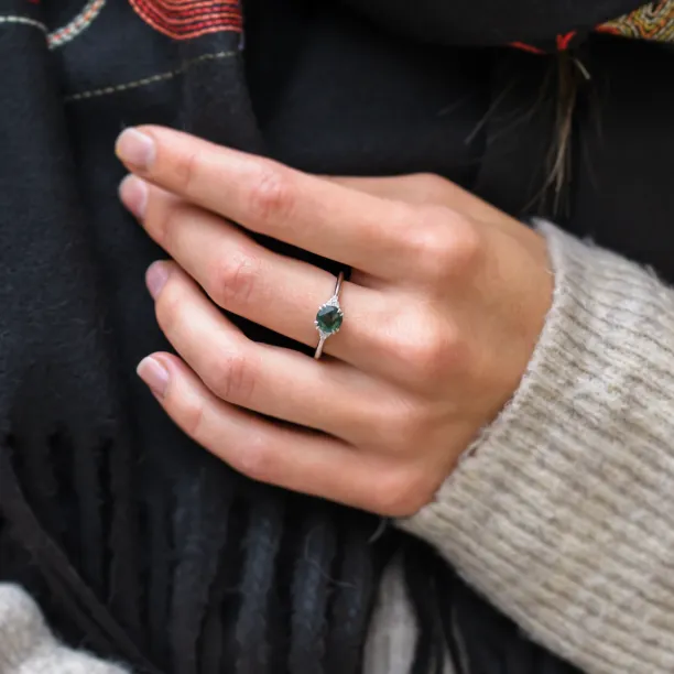 Moss agate and diamond engagement ring worn on the hand