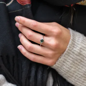 Moss agate and diamond engagement ring worn on the hand