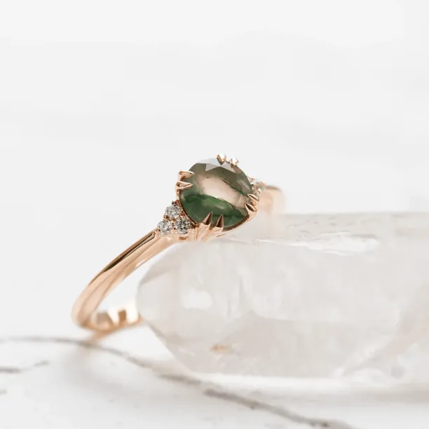 Angled close-up of the moss agate and diamond engagement ring