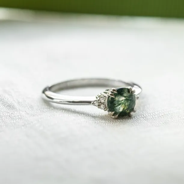 Angled view of the moss agate and diamond engagement ring