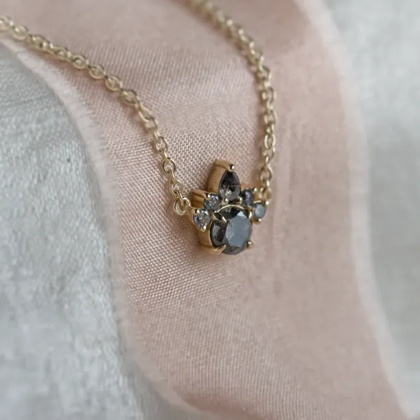 Angled close-up of the ASTRAL necklace pendant with salt and pepper diamonds