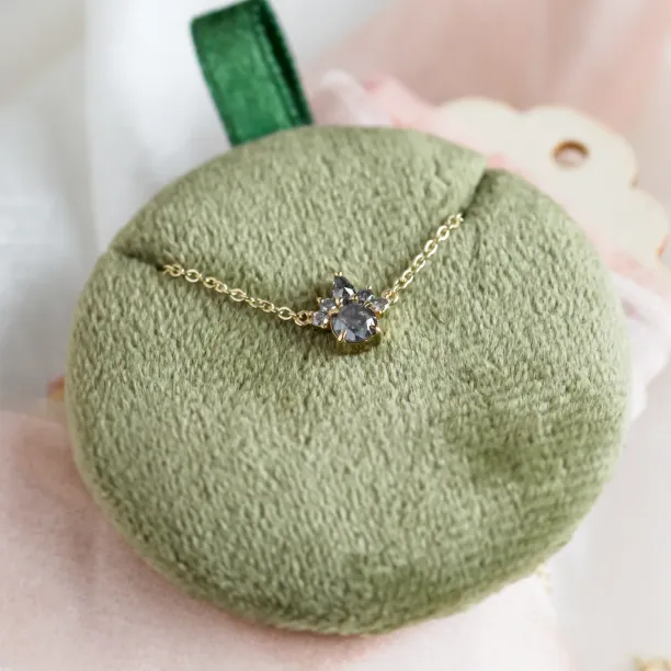 Close-up of the gold ASTRAL necklace pendant with salt and pepper diamonds