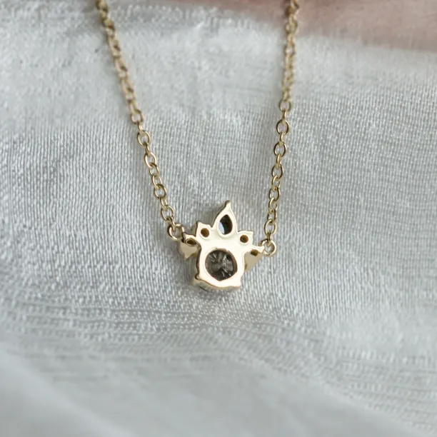 Back view of the gold ASTRAL necklace pendant and its salt and pepper diamond