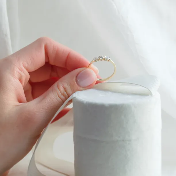 Gold AVERY ring with three moissanites held between fingers