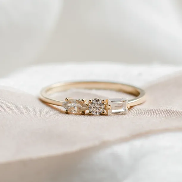 Gold ring with three moissanites in baguette, round and marquise cuts