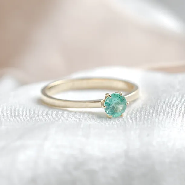 Angled view of the gold engagement ring with emerald JADE