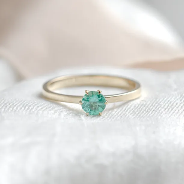 Gold engagement ring with emerald JADE in a centered front view